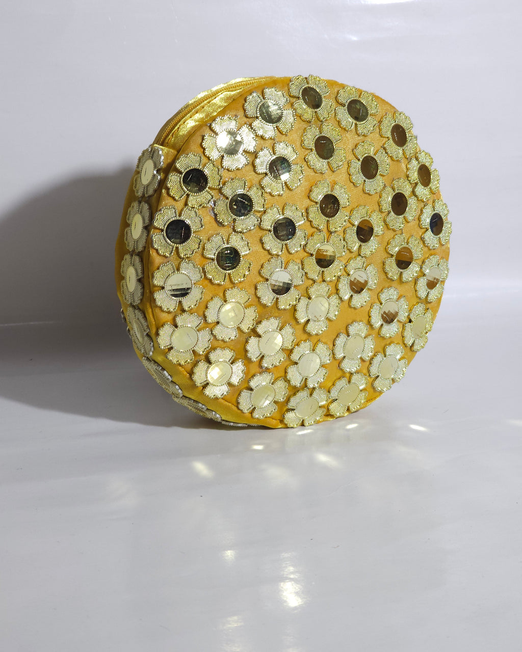 Round decorative CLUTCH BAG with gold and white floral patterns on a white background