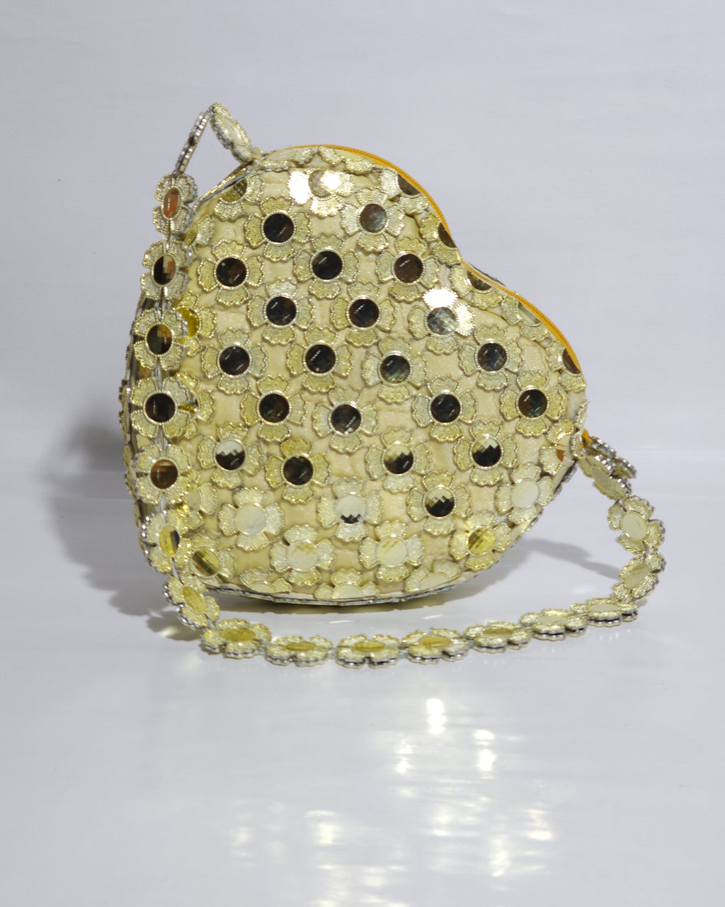 Heart-shaped handbag with sequin detailing on a white background