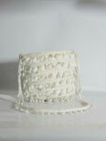 White woven handbag on a light gray background