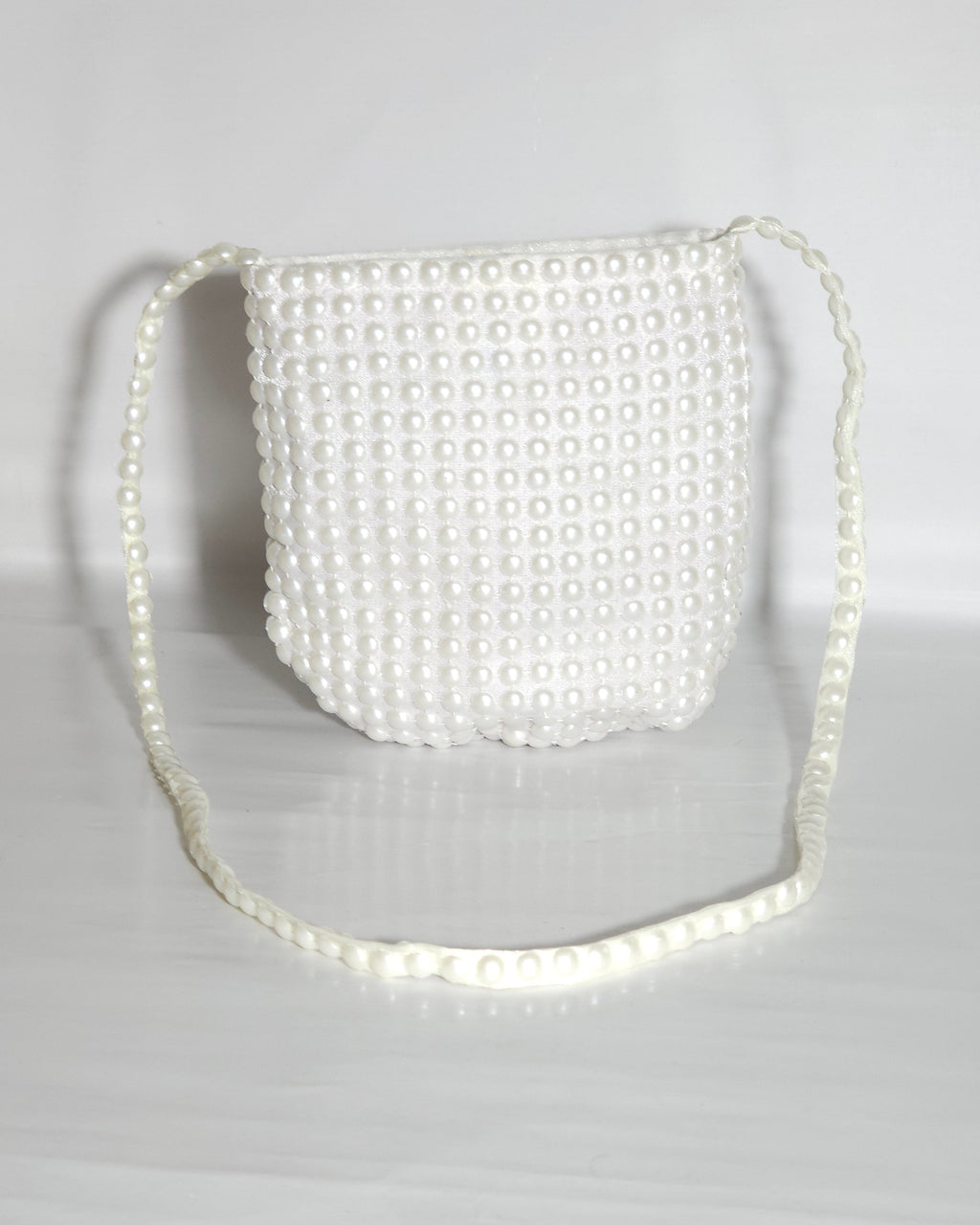 White pearl-handled bag on a light gray background