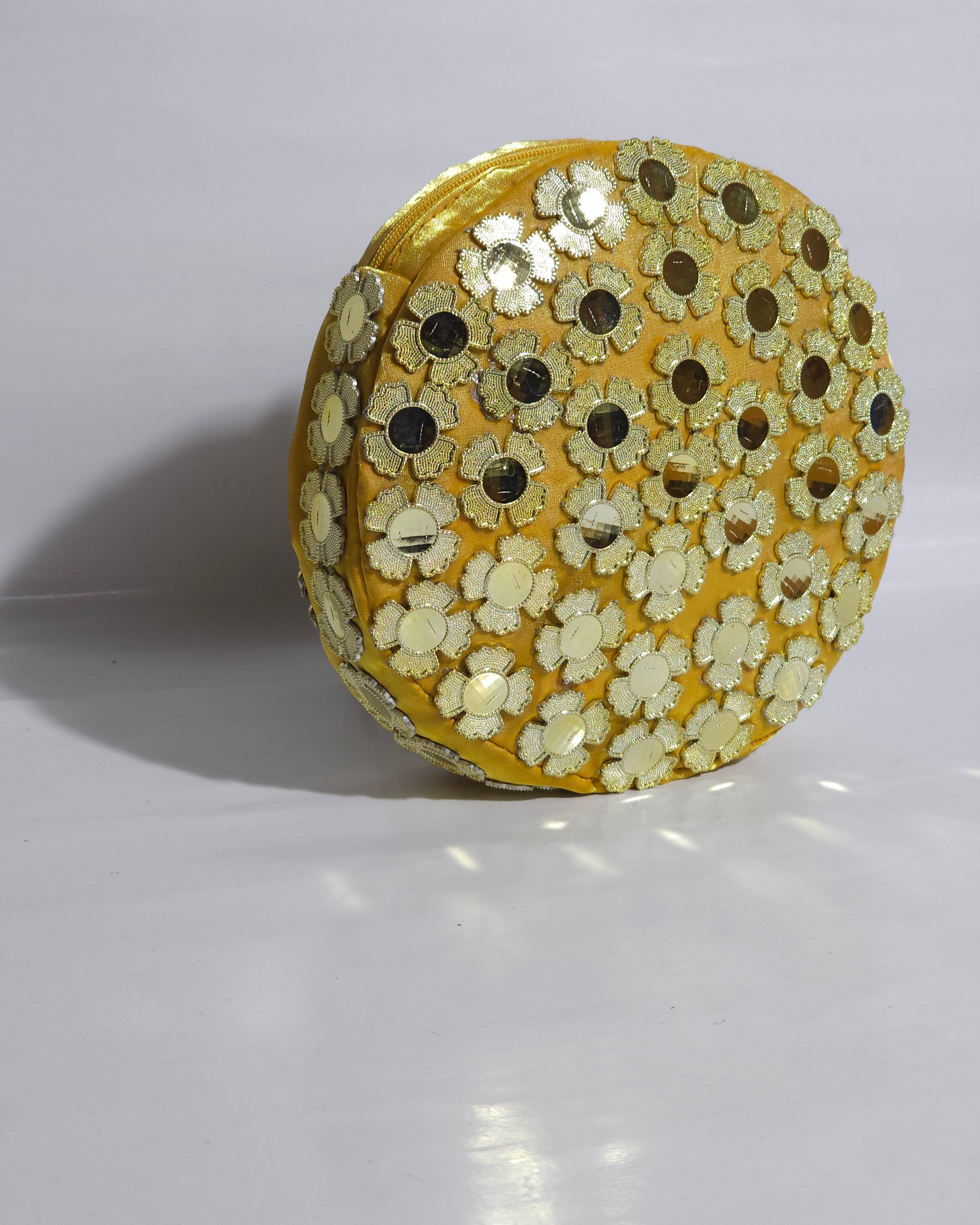Round GOLDEN YELLOW CLUTCH BAG with floral patterns on a white background
