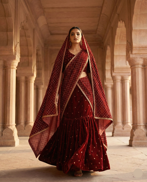 Woman in a red traditional outfit standing in an architectural setting